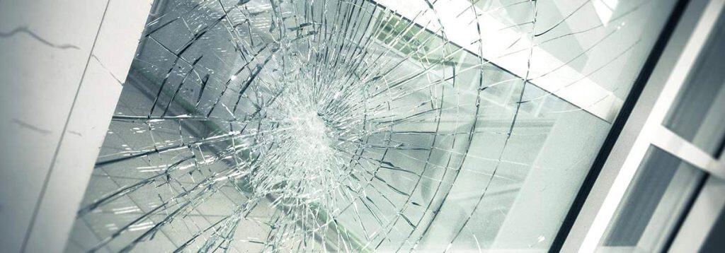 Cracked glass window with privacy film for home and office security.